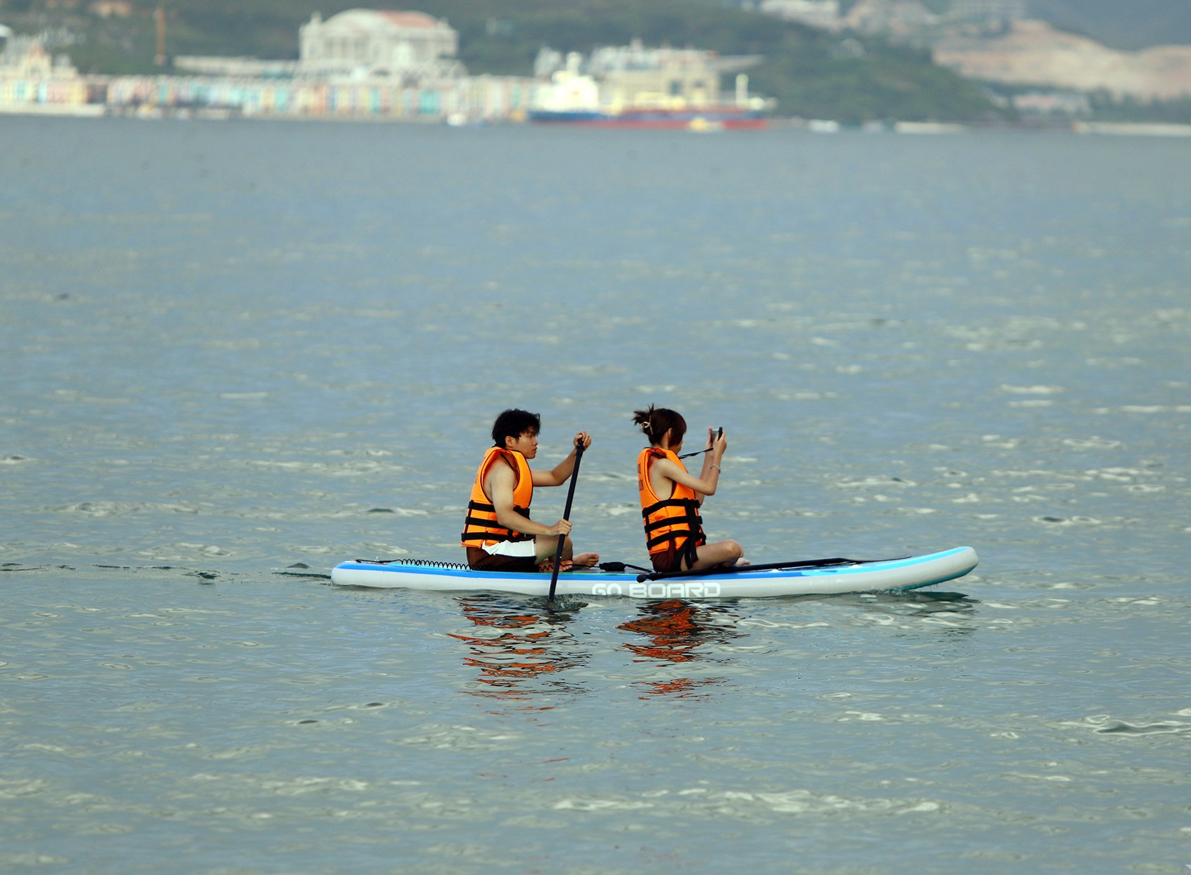 Paddleboarding and surfing activities on calm coastal waters