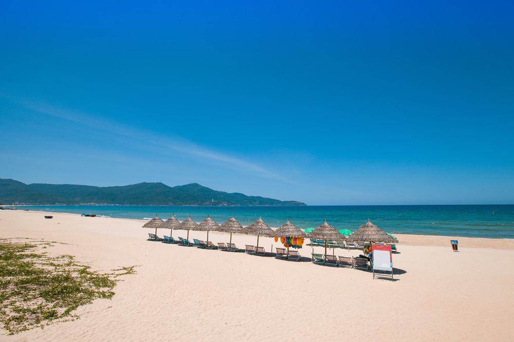 Soft white sand and clear blue water creating a peaceful and scenic coastal landscape.