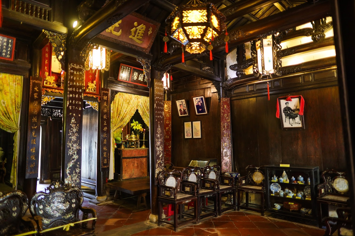 Traditional interior of a Vietnamese merchant house with wooden furniture and ancestral altar