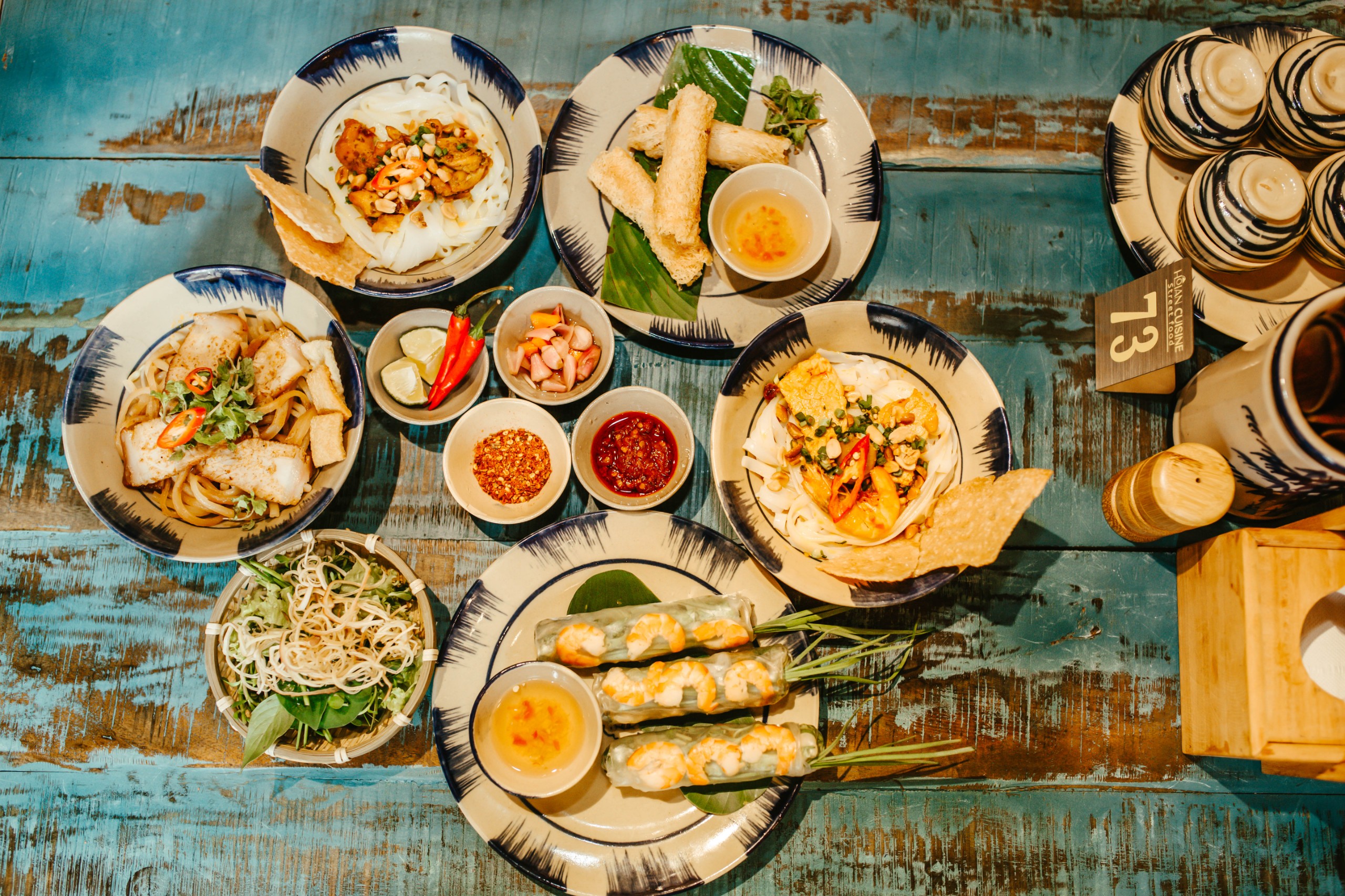 Travelers enjoying local dishes at a street market in Hoi An