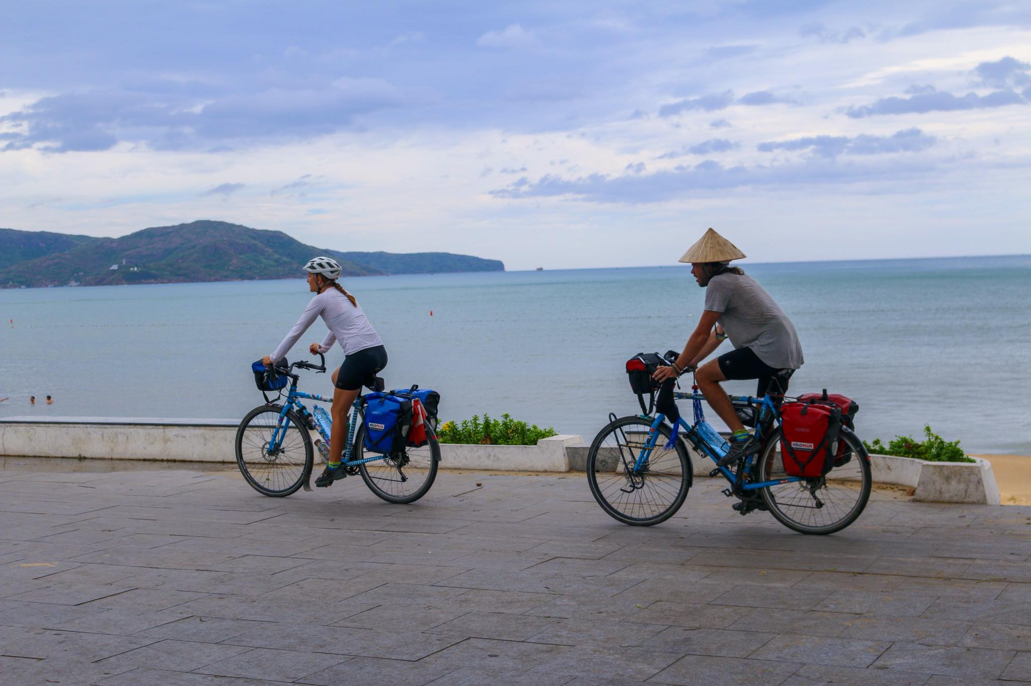 Travelers riding motorbikes along the coastal road near Hoi An