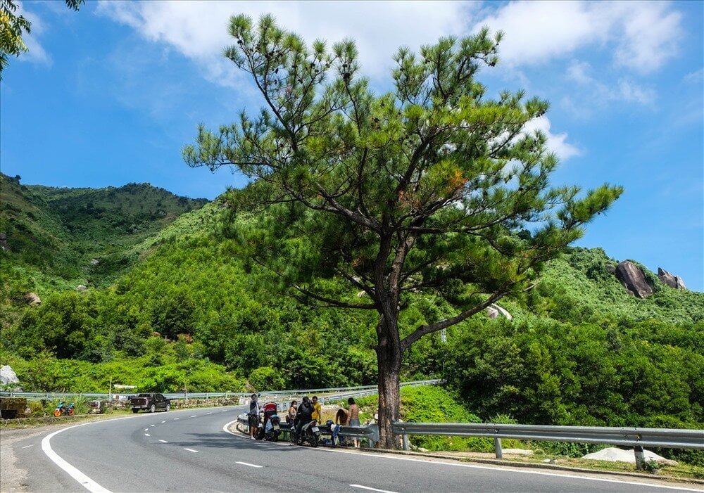 Visitors taking photos at the historic stone gate on the mountain pass